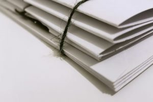 Pile de documents dans des pochettes reliées par une ficelle